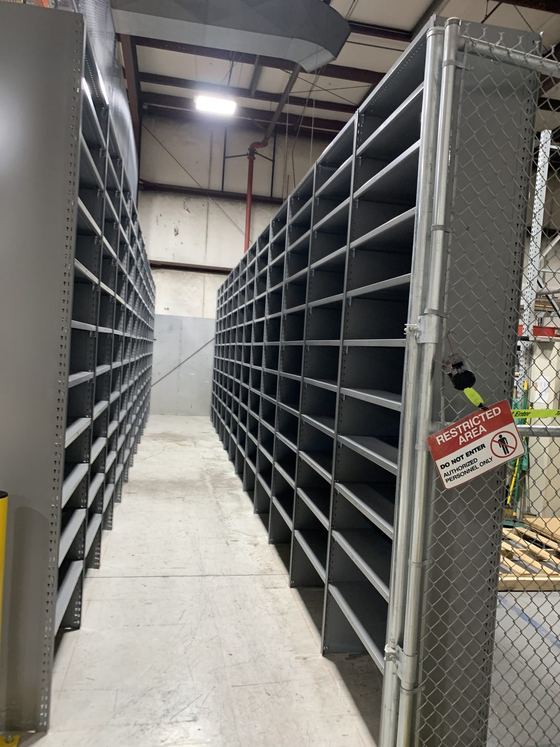 Steel shelving with dividers installed beneath a mezzanine