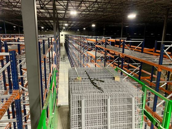 Pallet racking rows with wire decking seen from a mezzanine