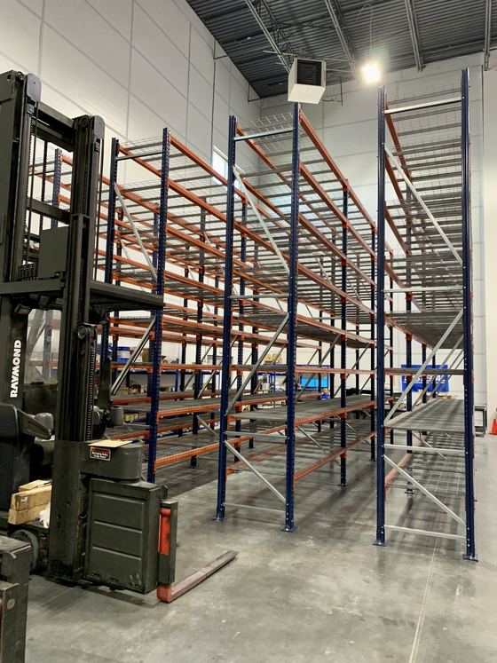 Tall pallet racking with wire decking and a reach truck